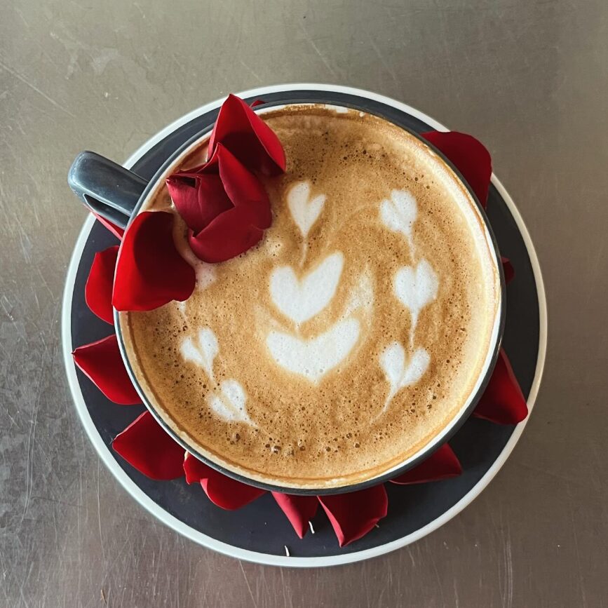 Latte with rose petals and foam art at French Press Bakery Needham MA